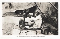 An Arab barber shaving a Swahili man
